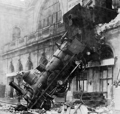 steam locomotive crashing out of a station