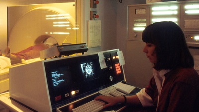 technician working at the screen of an MRI machine