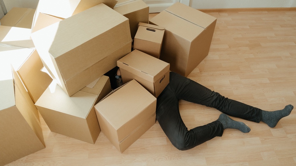person buried in moving boxes