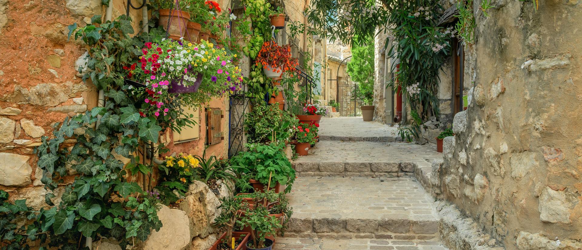 cobble stone steps up a flower draped stone alleyway